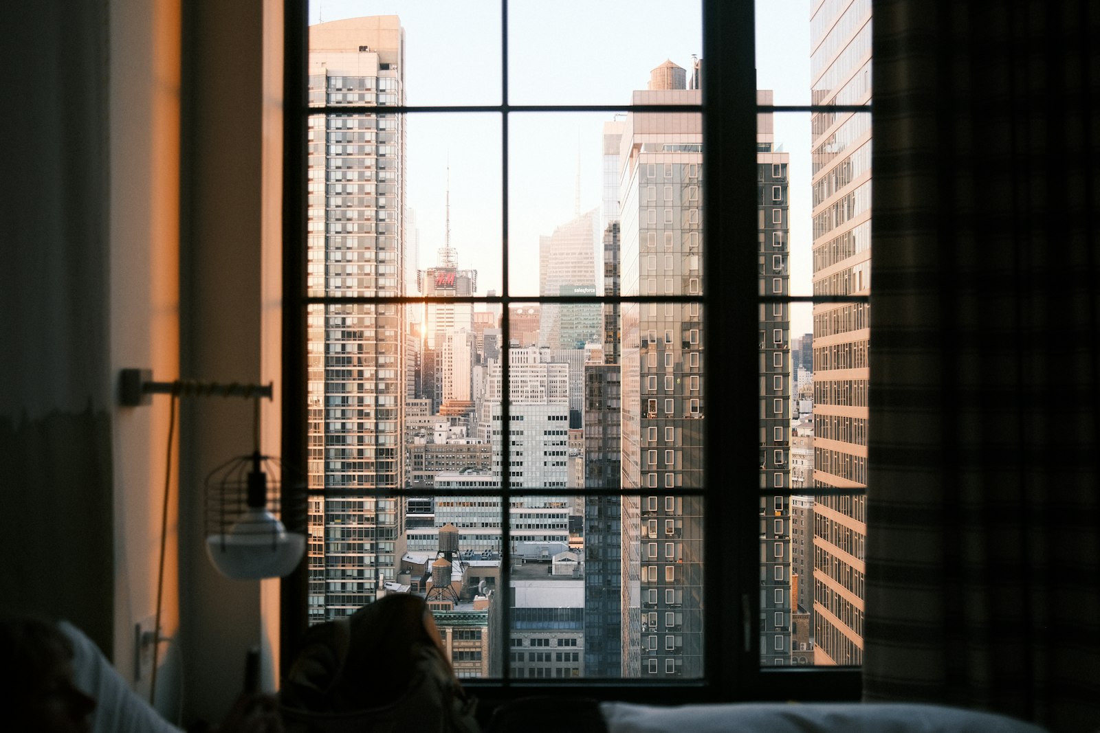 A city skyline at golden hour seen through a hotel room window